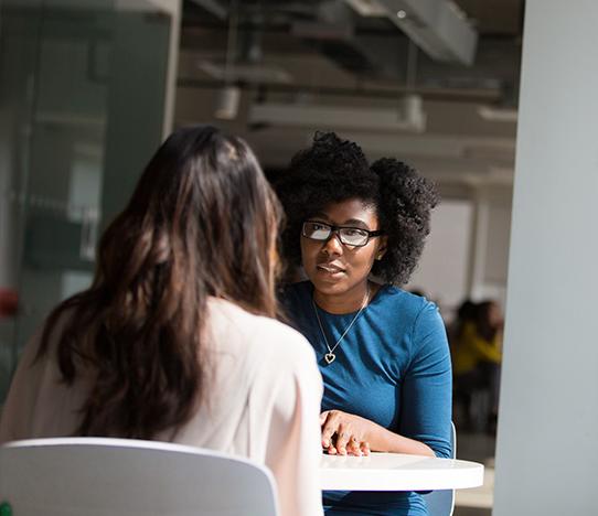 Two students a table talking